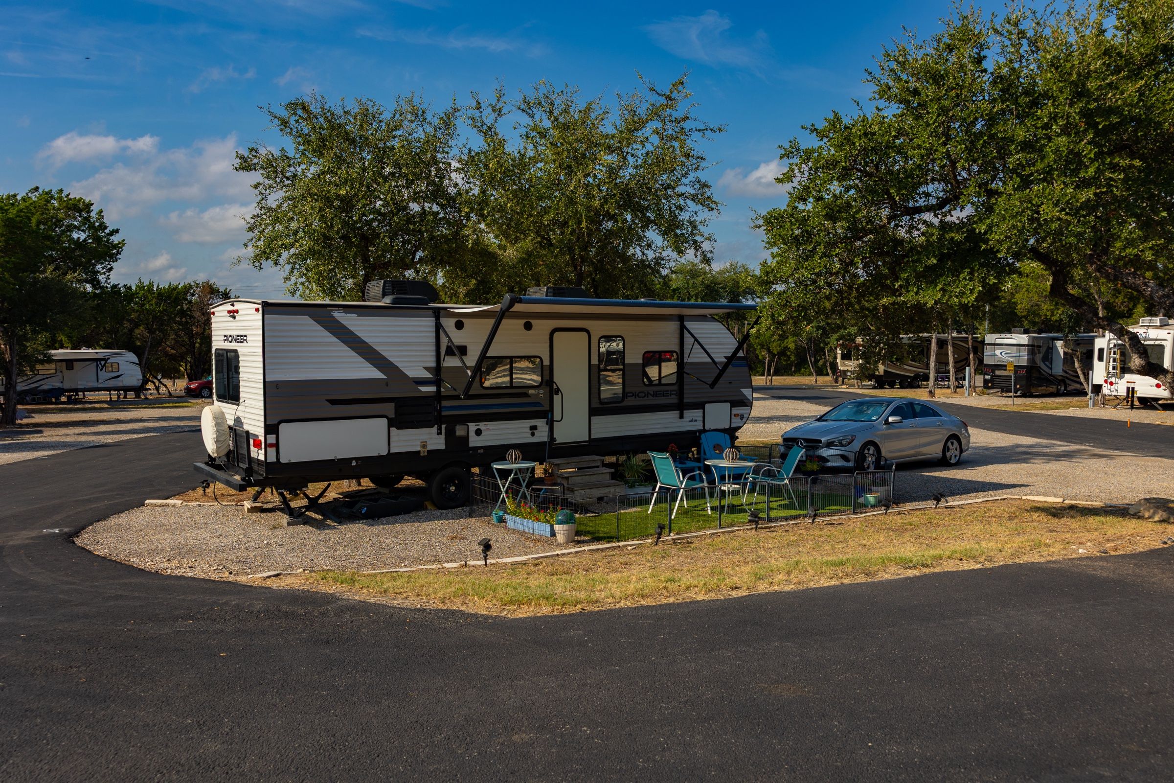 Travel trailer on a corner site with patio chairs